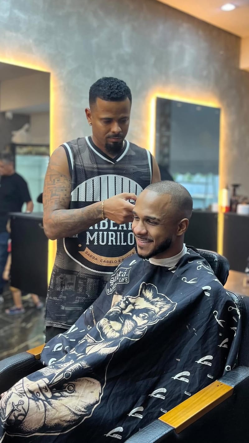 Murilo Malheiros cortando o cabelo do cantor Fabinho na Barbearia Murilo, Niterói