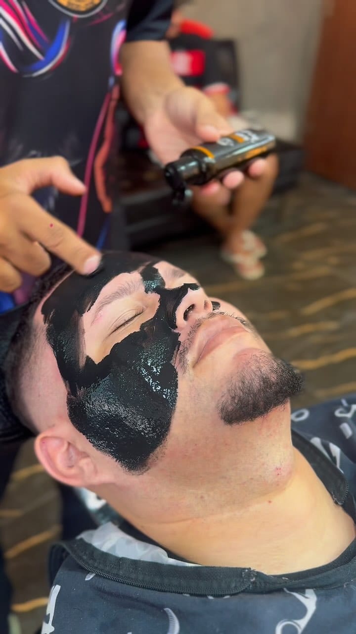 Limpeza de pele masculina com máscara de carvão durante o tratamento