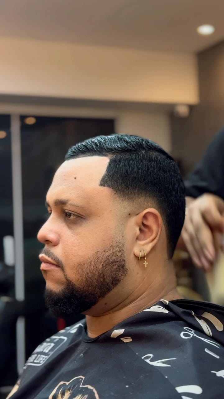 Corte com edge-up nítido, fade e barba alinhada, vista de perfil
